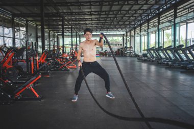 Sporcu, çapraz antrenmanda halat dalgalarını değiştiriyor..