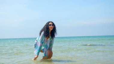 Genç kadınlar yaz tatillerinde denizde oynarlar ve gülümserler ve tatilde mutlu olurlar.