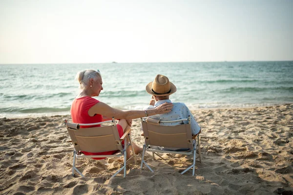 Para Starszych Ludzi Siedzących Krzesłach Plaży Oglądających Słońce Morze Podczas — Zdjęcie stockowe
