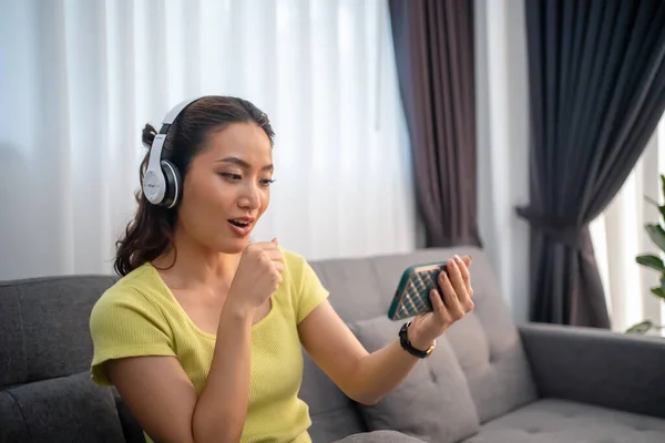 ヘッドフォンをして音楽に耳を傾け 休暇中に家で幸せを歌う女性 — ストック写真