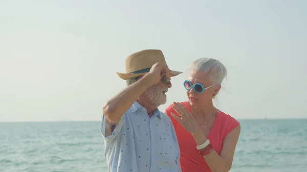 한연로 부부는 여름휴가 어깨를 해변에서 미소를 휴가를 즐긴다 — 스톡 사진