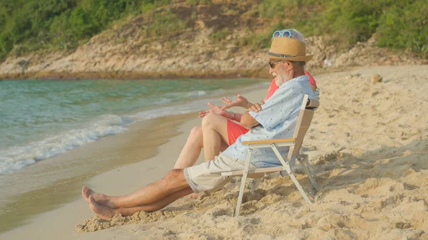 Casal Idosos Sentados Cadeiras Praia Assistindo Sol Mar Suas Férias — Fotografia de Stock