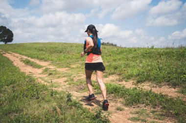 Akşamüstü dağın tepesinde koşan genç kadınlar, açık havada maceracı maraton koşucuları.