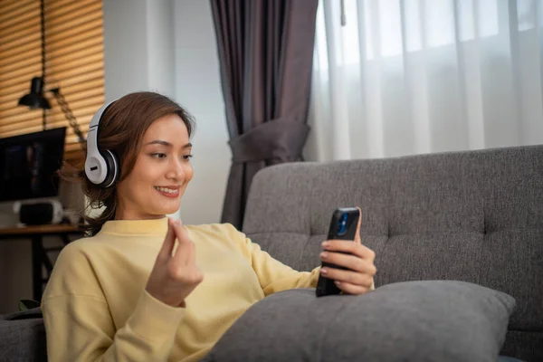 ヘッドフォンをして音楽に耳を傾け 休暇中に家で幸せを歌う女性 — ストック写真