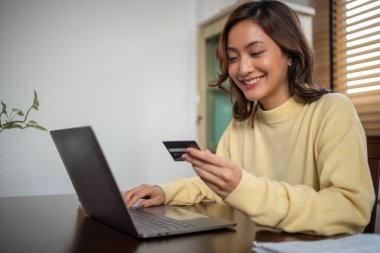 Akıllı telefon ve laptop kullanan kadınlar çevrimiçi alışveriş ve kredi kartıyla ödeme yapıyorlar.