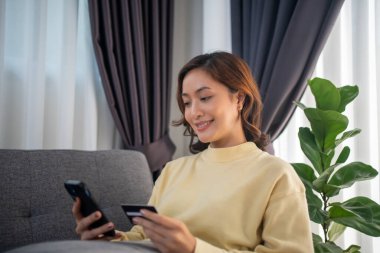 Akıllı telefon ve laptop kullanan kadınlar çevrimiçi alışveriş ve kredi kartıyla ödeme yapıyorlar.