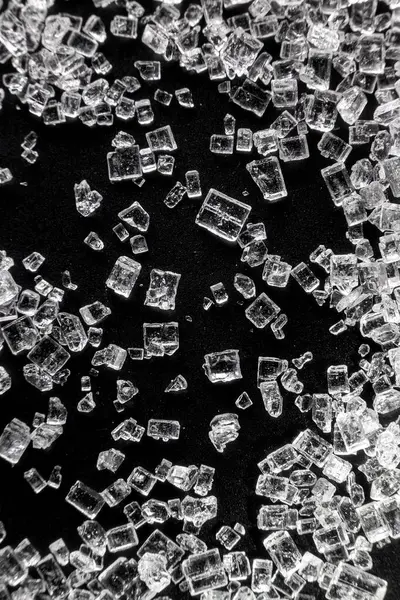 Sugar micro crystals shooted on a black - macro photo abstract background