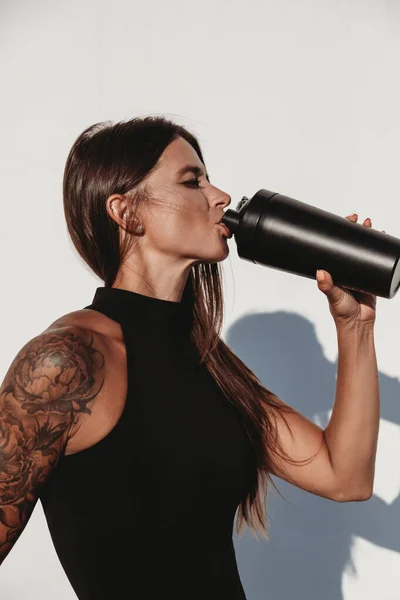 Beautiful Young Fit Tanned Caucasian Woman Tattoo Drinking Protein Shake Stock Image