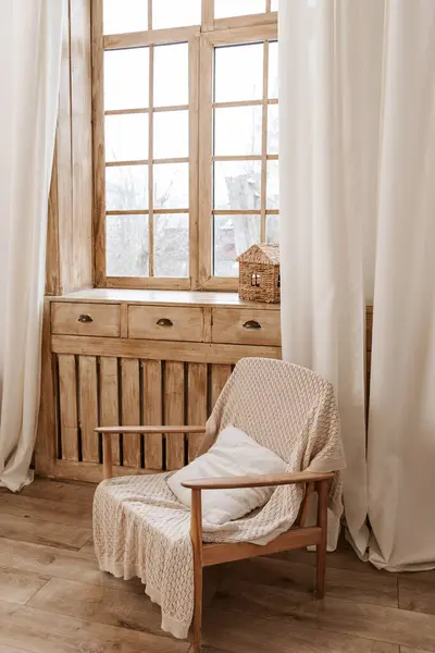 ベージュブランケット付きモダンな木製のラタンチェア付きのスタイリッシュな客室のインテリアデザイン ロイヤリティフリーのストック画像