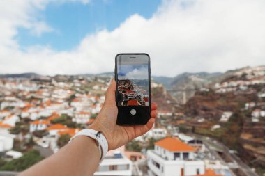 Portekiz 'in Madeira Adası' ndaki Funchal şehrinin cep telefonundan fotoğraf çeken kız.