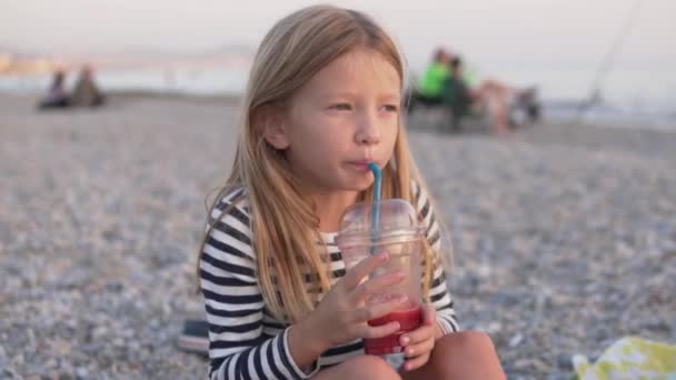 面白い女の子は海のプラスチックガラスからザクロジュースを飲む コンセプト子供たちは海で育ちます 子供と一緒に旅行する トルコ アラニヤ 10月 — ストック動画