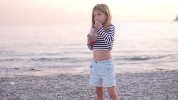 Ein Kleines Mädchen Weste Trinkt Bei Sonnenuntergang Frisch Gepressten Granatapfelsaft — Stockvideo