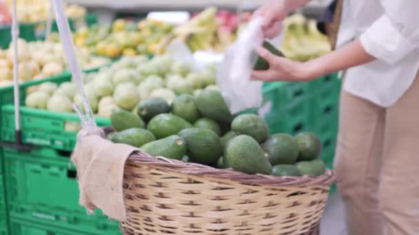 Uma Mulher Compra Abacates Num Supermercado Comprador Mão Seleciona Frutas — Vídeo de Stock
