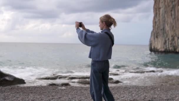 一个女人在黄昏时拍了一张大海的照片 — 图库视频影像