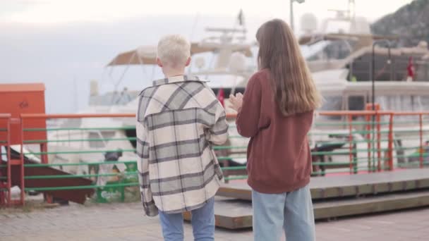 从后面看去 孩子们在吃冰淇淋 看港口的游艇 — 图库视频影像
