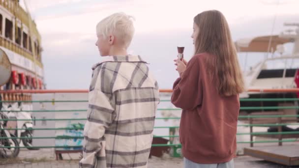 Ein Paar Teenager Essen Eis Und Betrachten Die Schiffe Auf — Stockvideo