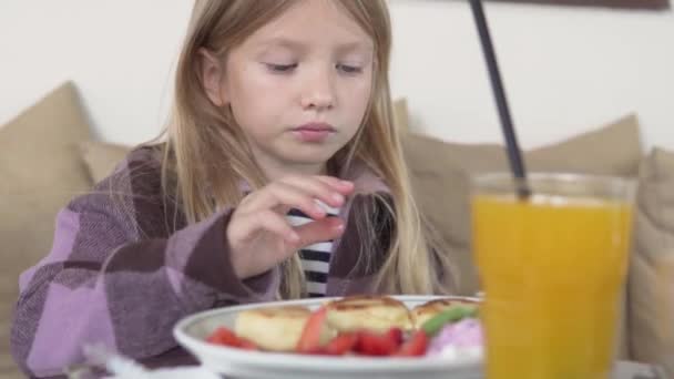 Una Niña Desayuna Restaurante Queso Cottage Con Fresas Zumo Naranja — Vídeos de Stock
