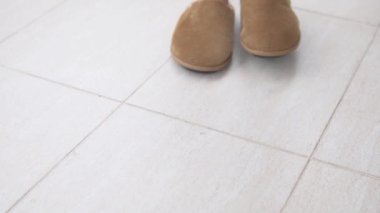 Kürk ayakkabılı kadınlar fayansta ileri geri yürür..