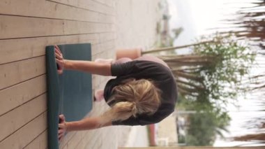 Dikey video, parktaki karın kasları üzerinde egzersiz yapan bir kadın..