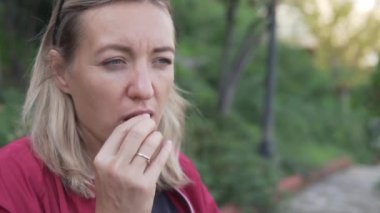 Yakın plan, bir kadın dışarıda sakız çiğniyor..