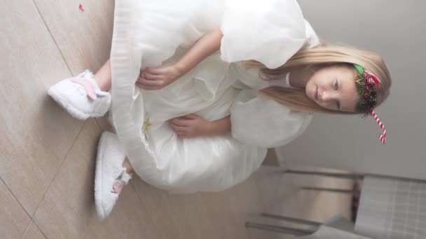 Ένα Κομψό Κοριτσάκι Κάθεται Στο Πάτωμα Ένα Πλούσιο Λευκό Φόρεμα — Αρχείο Βίντεο