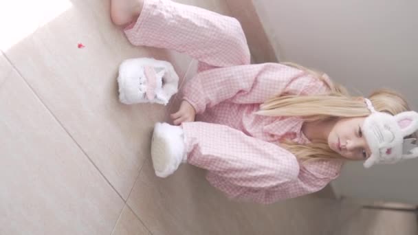 Egy Cuki Pizsamás Kislány Meleg Prémes Papucsot Tesz Lábára Függőleges — Stock videók