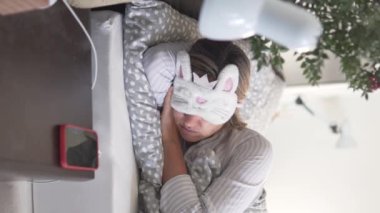 Dikey video, bir kadın sabah evde telefonundaki çalar saatle uyanır..