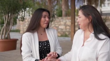 Yetişkin bir anne ve kızın, parkta gülüp konuşan güzel kadınların buluşması..