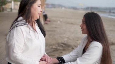 Doğulu görünüm konuşmalarının güzel anne ve kızı, güzel kız annesini dinliyor ve ona gülümsüyor. Türkmenistan 'dan ayrılan kadınlar.