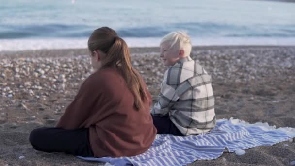 View Boy Girl Jackets Sitting Pebble Beach Looking Sea — 비디오