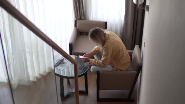 Vrouw Hotelkamer Zit Een Stoel Gebruikt Een Mobiele Telefoon — Stockvideo