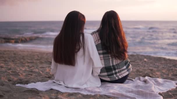 Δύο Όμορφες Μελαχρινές Γυναίκες Κάθονται Μια Κουβέρτα Και Βλέπουν Ηλιοβασίλεμα — Αρχείο Βίντεο