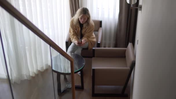 Kobieta Turystka Pokoju Hotelowym Siedzi Krześle Telefonem Komórkowym Rękach — Wideo stockowe
