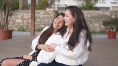 Güzel esmer kadınlar parkta kucaklaşır, anne ve kızı birlikte mutludurlar. Türkiye, Alanya