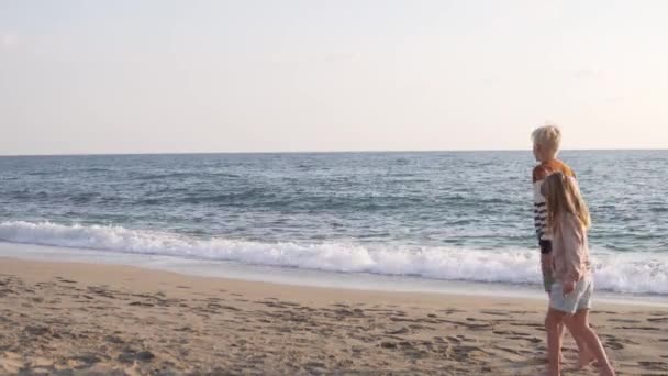 Sarışın Bir Çocuk Kumlu Bir Plajda Bir Kızla Ele Yürüyor — Stok video