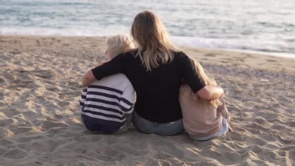 Mama Siedzi Plaży Uścisku Dziećmi Chłopcem Dziewczyną Widok Tyłu — Wideo stockowe