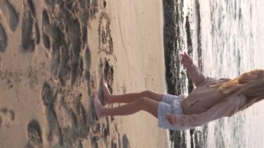 Dikey video, kışın sahilde oynayan küçük kız. Türkiye, Alanya