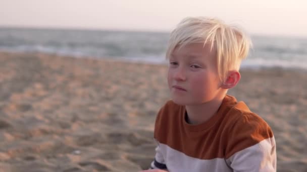 Handsome Blond Boy Sits Beach Sea — Stok Video