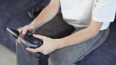 Close-up of a womans hands with a game joystick and a phone.
