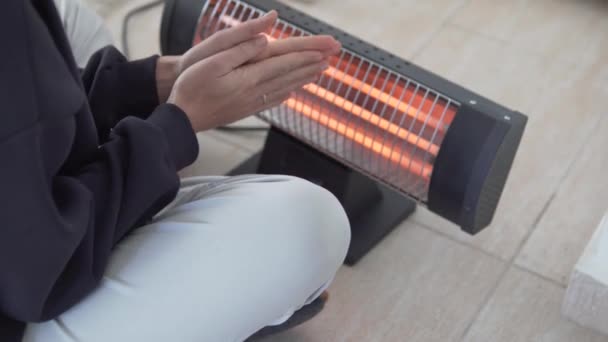 Frozen Woman Warms Her Hands Electric Battery — Stock video