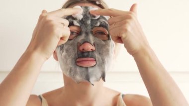 A woman makes herself a cleansing face mask, close-up.