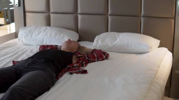 Усталая Женщина Лежит Кровати Своей Одежде — стоковое видео