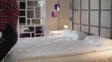 A happy woman falls on her back on a bed in a hotel. Turkey, Kemer