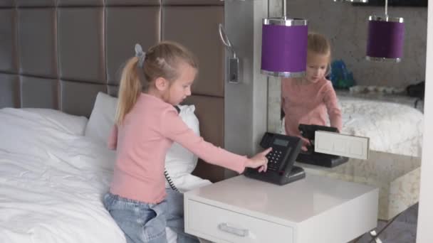 Beautiful Little Girl Sits Bed Hotel Dials Phone Number — Vídeos de Stock