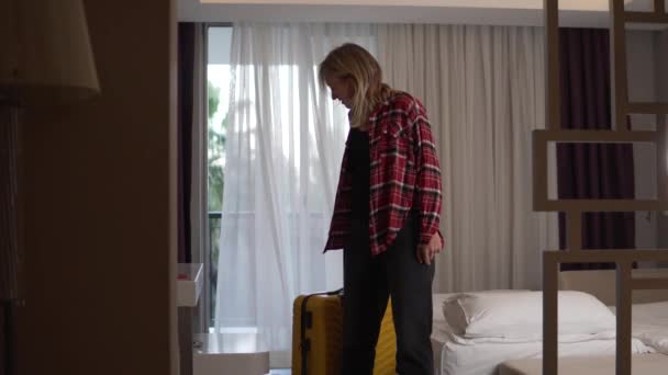 スーツケース付きの女性観光客がホテルの部屋にチェックイン — ストック動画