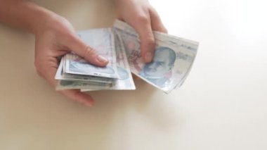 Close-up, hands count a pack of Turkish liras.