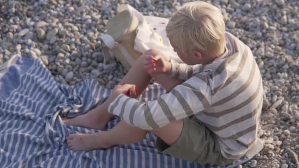 View Blond Boy Eating Marmalades Pebble Beach — Vídeo de stock