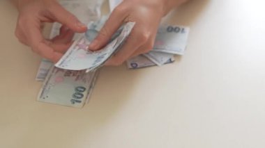 A person counts down money to pay bills for utilities in Turkey.
