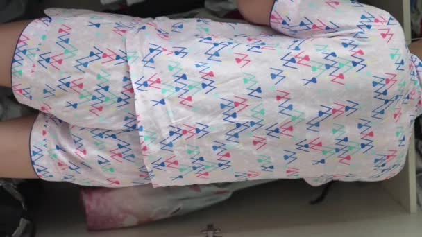 一个穿着睡衣的女人在衣柜里整理孩子们的衣服 垂直录像 — 图库视频影像