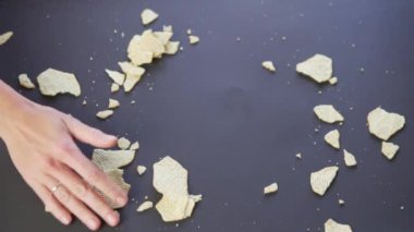 Kadınların elleri siyah arkaplana saçılmış çipleri kaldırır.